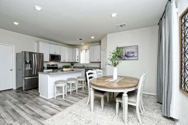 dining area with recessed lighting, visible vents, baseboards, and light wood-style floors