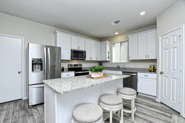 kitchen with light wood-style floors, a kitchen island, visible vents, and stainless steel appliances