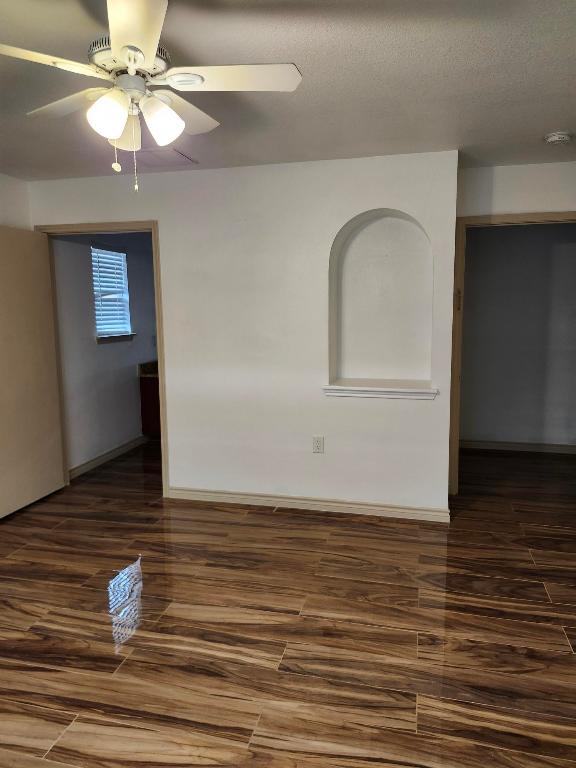 spare room featuring baseboards, a ceiling fan, and wood finished floors