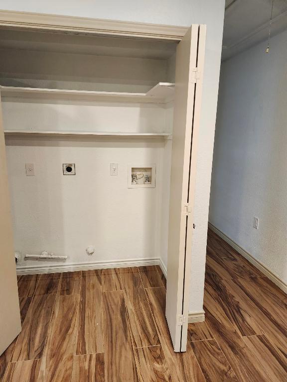 clothes washing area with hookup for an electric dryer, baseboards, laundry area, hookup for a washing machine, and wood finished floors