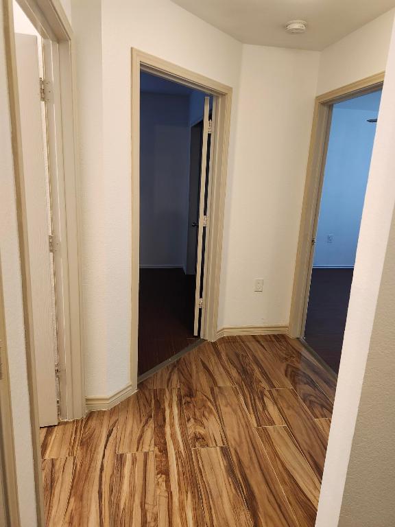 hallway with baseboards and wood finished floors
