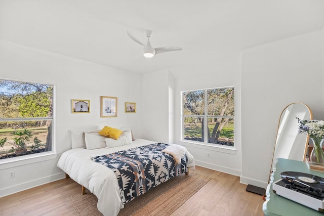 bedroom with baseboards, wood finished floors, and a ceiling fan