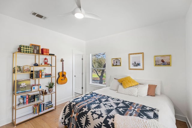 bedroom featuring visible vents, ceiling fan, baseboards, and wood finished floors