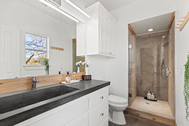 bathroom with vanity, toilet, and a stall shower