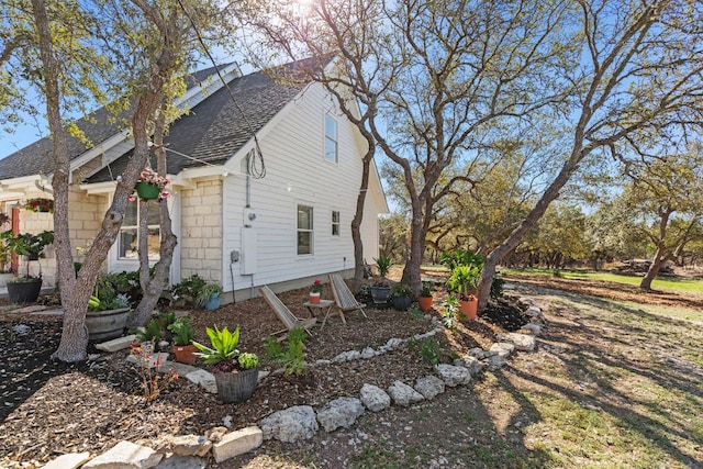 view of property exterior with a shingled roof