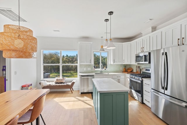 kitchen with a sink, white cabinets, visible vents, and stainless steel appliances