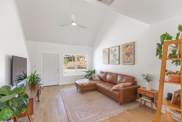 living area featuring high vaulted ceiling, visible vents, light wood finished floors, and ceiling fan