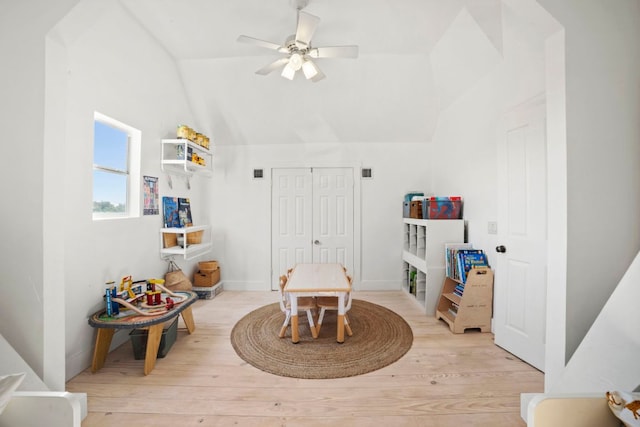 interior space with baseboards, light wood-style floors, a ceiling fan, and vaulted ceiling