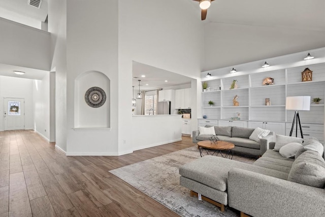 18516 Silent Water Way, Pflugerville, TX 78660 - living area featuring a towering ceiling, plenty of natural light, wood finished floors, baseboards, and ceiling fan