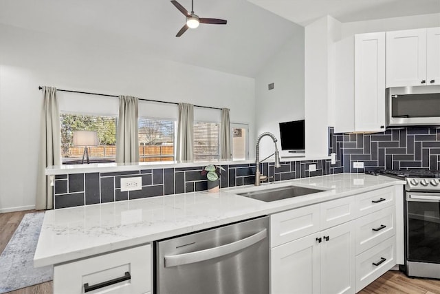 18516 Silent Water Way, Pflugerville, TX 78660 - kitchen with appliances with stainless steel finishes, a sink, decorative backsplash, a ceiling fan, and high vaulted ceiling