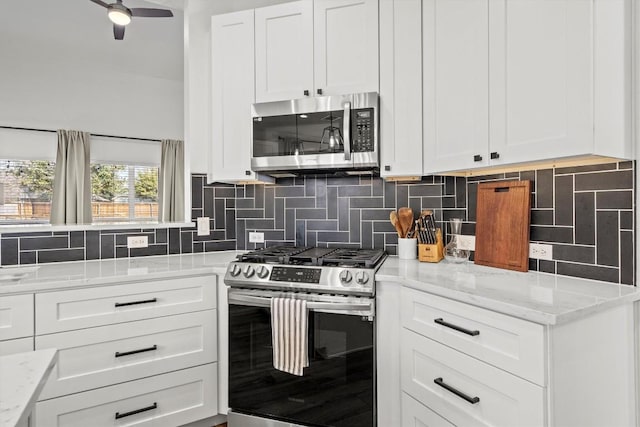 kitchen featuring backsplash, white cabinets, stainless steel appliances, and ceiling fan