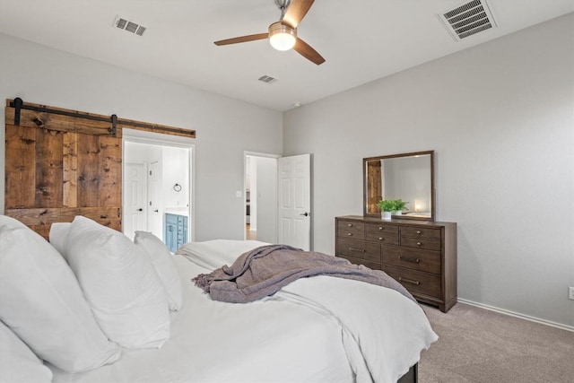 bedroom featuring visible vents, ensuite bathroom, and light carpet