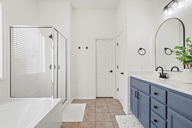 bathroom with tile patterned flooring, a shower stall, vanity, and a tub to relax in