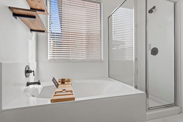 bathroom featuring a bath and a shower stall