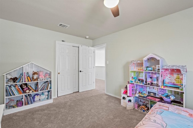 carpeted bedroom with visible vents, baseboards, a closet, and a ceiling fan