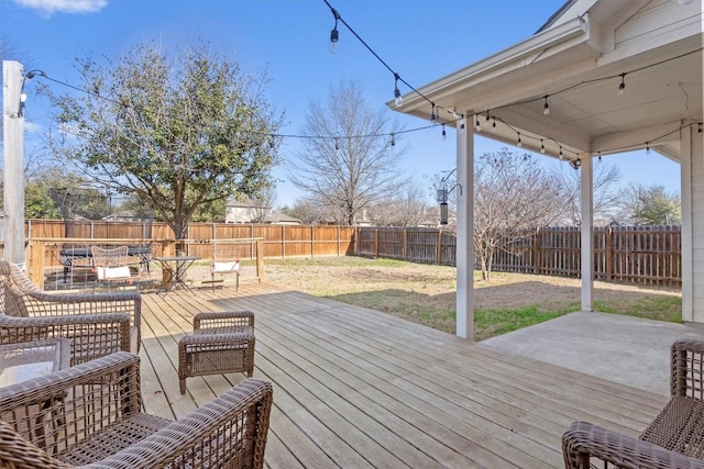 wooden terrace featuring a yard, outdoor dining space, a patio area, and a fenced backyard