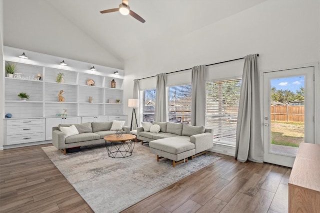 living room with ceiling fan, high vaulted ceiling, and wood finished floors