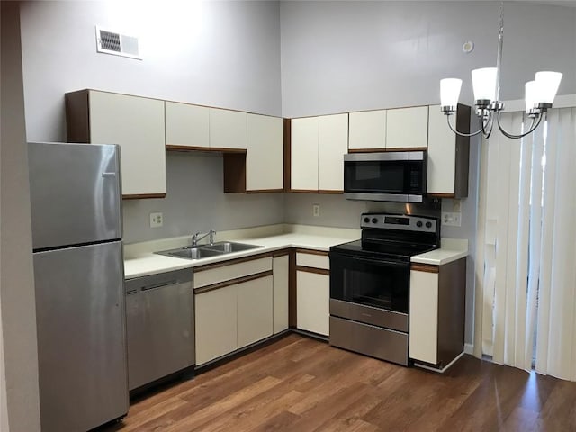 kitchen featuring a sink, stainless steel appliances, visible vents, and light countertops