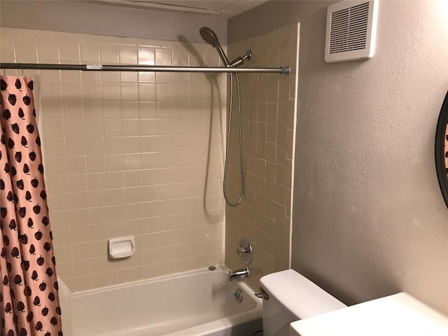 bathroom featuring a textured wall, visible vents, toilet, and shower / bath combination with curtain