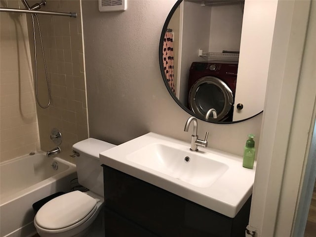 bathroom featuring toilet, washer / clothes dryer, shower / tub combo, vanity, and a textured wall