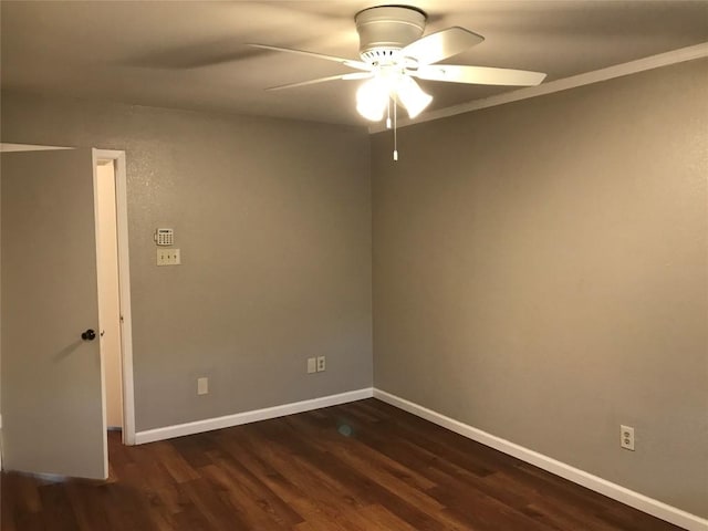 spare room with baseboards, dark wood-style flooring, and ceiling fan