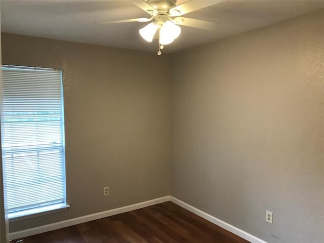 empty room with baseboards, dark wood-style floors, and a ceiling fan