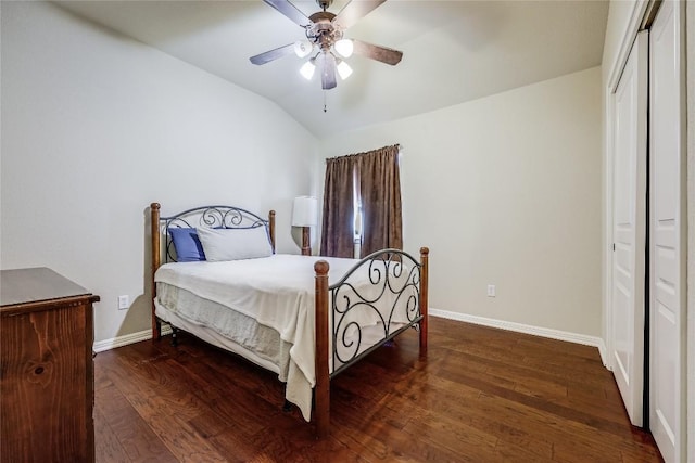 bedroom featuring baseboards, lofted ceiling, wood finished floors, a closet, and a ceiling fan