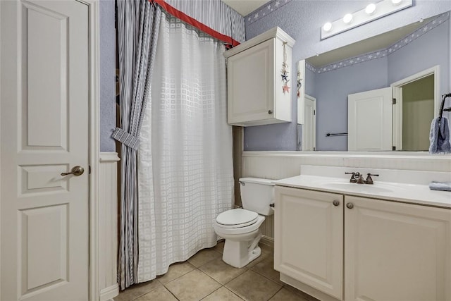 full bathroom featuring tile patterned floors, toilet, curtained shower, wallpapered walls, and vanity