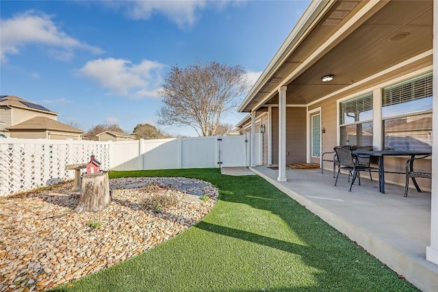 view of yard with a patio, fence, and a gate