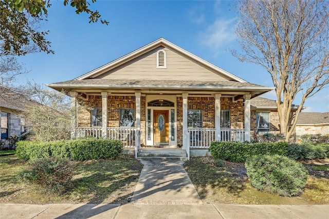 view of front of home with brick siding and covered porch