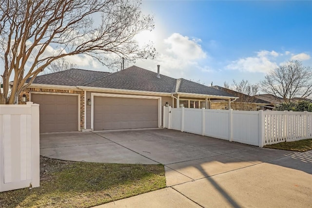 garage with fence and driveway