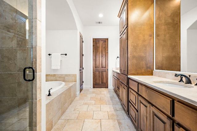 full bathroom featuring vanity, a bath, visible vents, and a stall shower