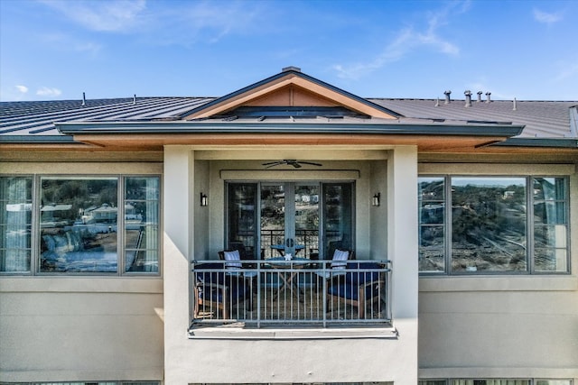 entrance to property with a standing seam roof, a ceiling fan, and metal roof