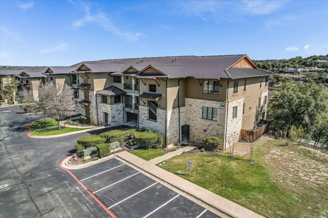 view of building exterior with a residential view and uncovered parking