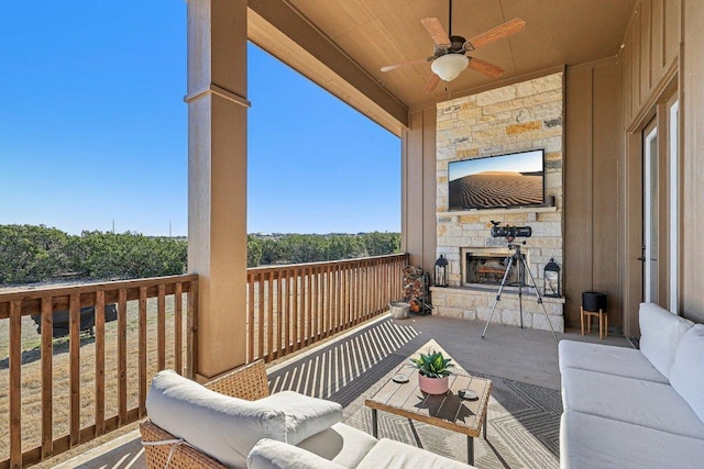 deck featuring an outdoor living space with a fireplace and ceiling fan