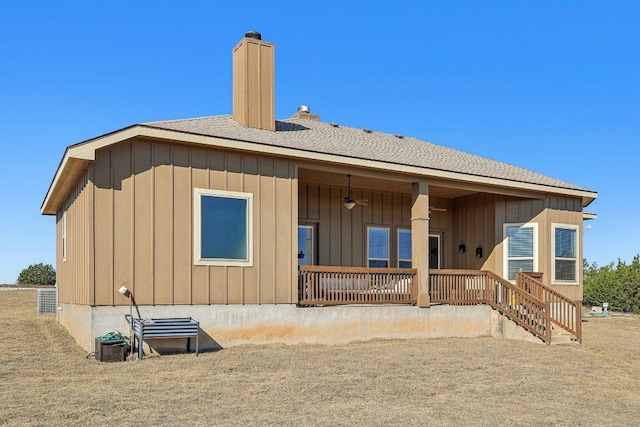 rear view of house with a porch, board and batten siding, and a chimney