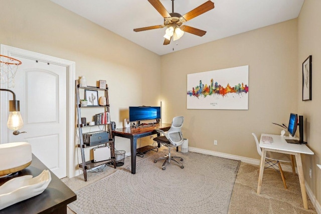 carpeted office featuring baseboards and ceiling fan