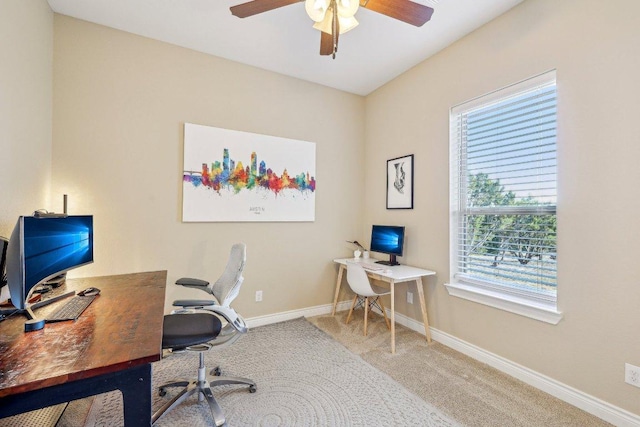 carpeted home office featuring baseboards and a ceiling fan