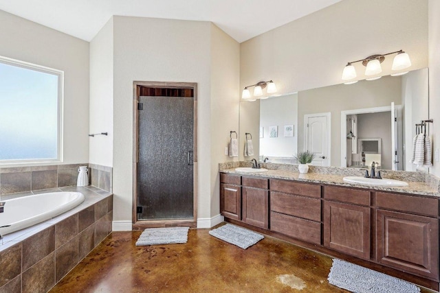 bathroom featuring a sink, a garden tub, a stall shower, and double vanity