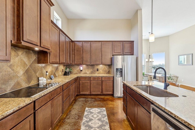 kitchen featuring a sink, stainless steel appliances, decorative backsplash, light stone countertops, and hanging light fixtures