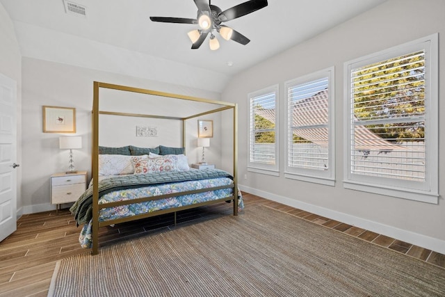 bedroom featuring vaulted ceiling, baseboards, visible vents, and wood finish floors