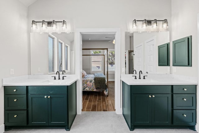 ensuite bathroom featuring wood tiled floor, two vanities, ensuite bathroom, and a sink