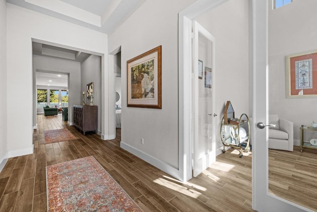 hallway featuring wood finish floors and baseboards