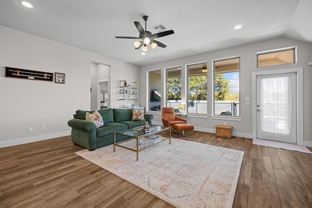 living area featuring baseboards, wood finished floors, visible vents, and ceiling fan