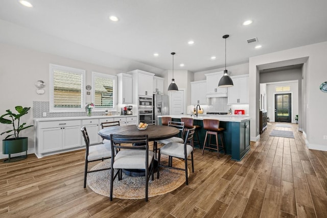 dining space featuring recessed lighting, visible vents, light wood-type flooring, and baseboards