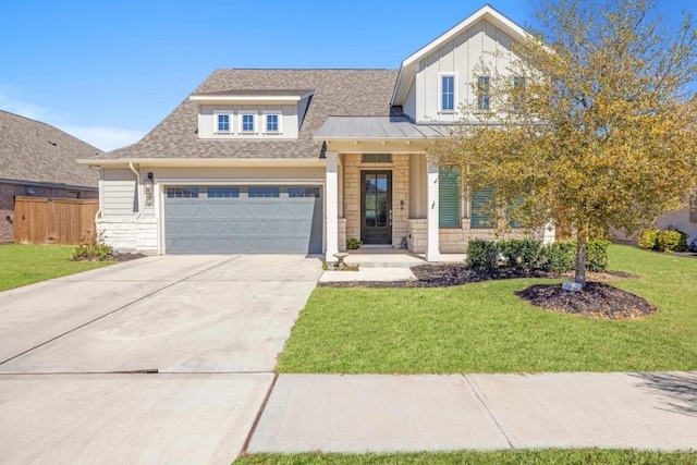 view of front facade with a front yard, driveway, a shingled roof, a garage, and stone siding