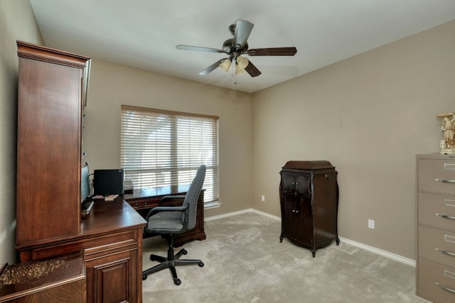 home office featuring light colored carpet, baseboards, and ceiling fan