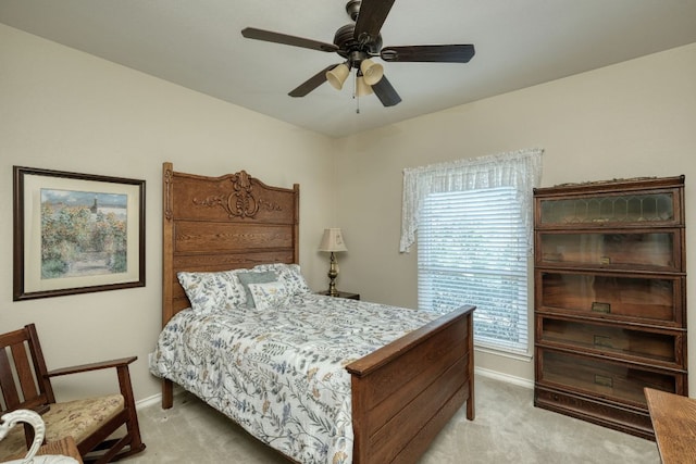 bedroom with light colored carpet, baseboards, and ceiling fan