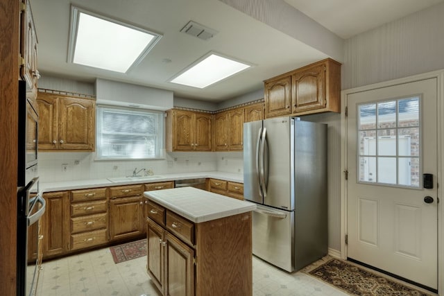 kitchen featuring light floors, brown cabinets, and appliances with stainless steel finishes