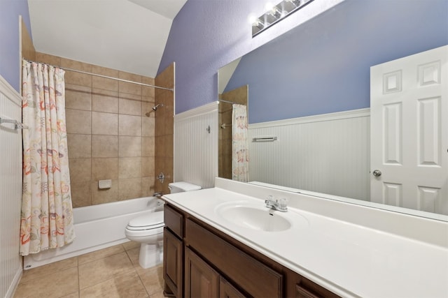 full bath featuring vanity, tile patterned flooring, shower / bath combination with curtain, wainscoting, and toilet